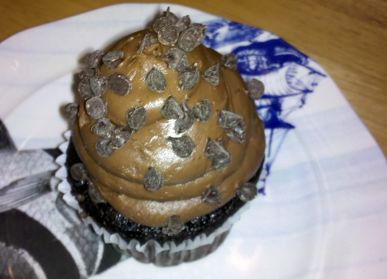 A cupcake topped with a
swirl of thick, ropey, brown icing